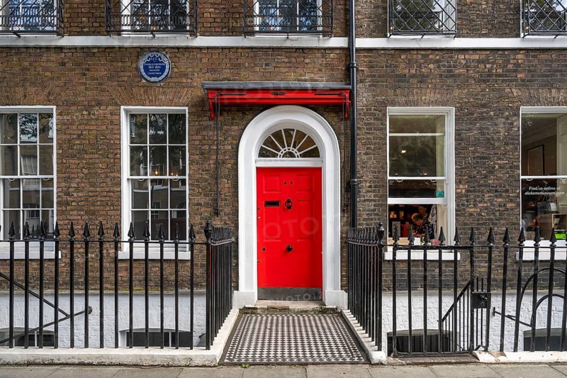 Red entrance door in a brick building with a cast-iron fence, Charles Dickens Museum, 48-49 Doughty Street, Holborn, London Borough of Camden, England, United Kingdom, Europe