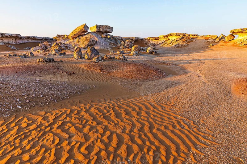 Striking cliffs surrounded by windswept sand structures, Huqf stone desert, Arabian Peninsula, Sultanate of Oman