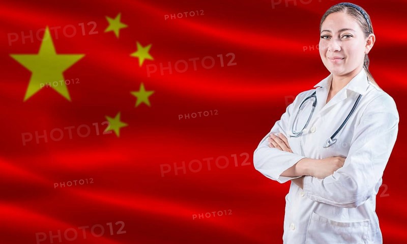 Female doctor on China flag. Doctor with crossed arms on China flag. China Health and Care concept