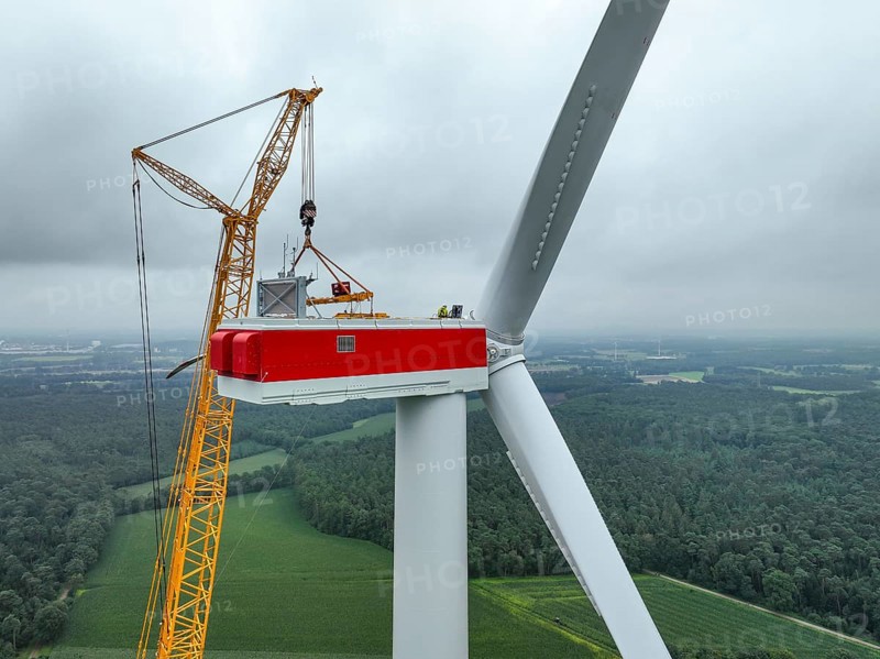 Dorsten, North Rhine-Westphalia, Germany, construction of a wind turbine. A large mobile crane lifts a rotor blade to the nacelle on the tower. Here, the blade is mounted directly on the motor hub. Große Heide wind farm, Europe