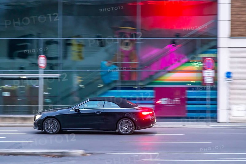 Mercedes at night in front of urban surroundings with modern architecture, pull-along. Stuttgart, Baden-Württemberg, Germany, Europe