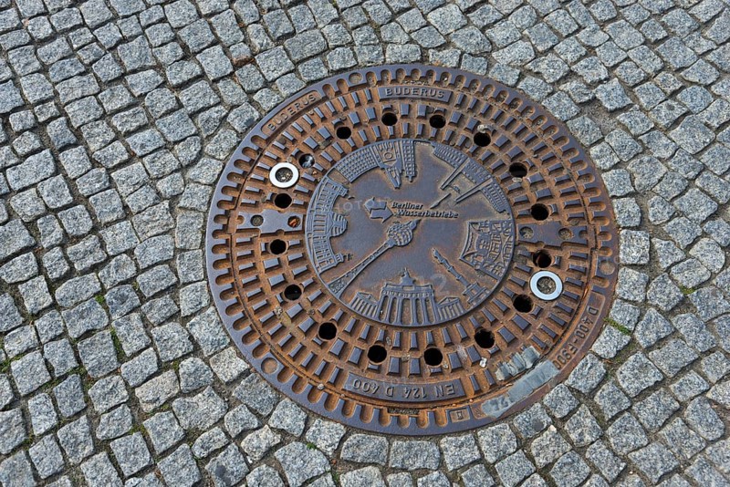 Artfully designed manhole cover on paved street in Berlin, gully cover, manhole cover, Berlin, Germany, Europe