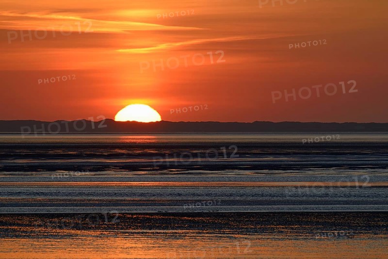 Sunset over the North Sea at low tide, the outline of the island of Juist on the horizon, Norddeich, Lower Saxony, Germany, Europe