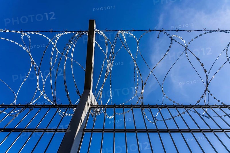 Symbolic image security, S-wire rolls, NATO wire, on a fence top, demarcation of a property, prevention of unauthorised access, strip steel wire with sharp blades