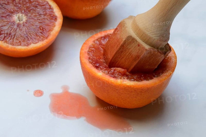 Halved blood orange with citrus squeezer, orange