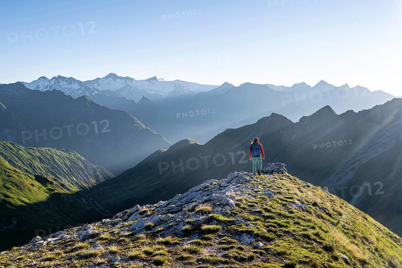Hiker enjoying the mountain panorama in the morning, Venediger group, behind Dreiherrenkopf, Simonysitze and Großer Geiger, Hohen Tauern, Austria, Europe