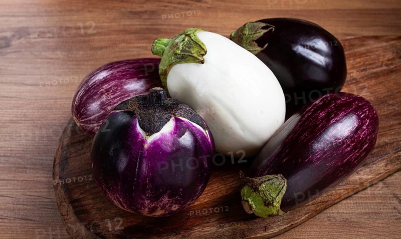 Colored eggplants, on a wooden table, white, purple and black eggplants, top view, raw eggplants, without people