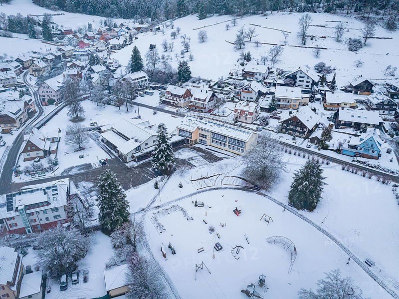 Snowy village with playground, surrounded by hills and trees, Enzklösterle, Calw district, Black Forest, Germany, Europe