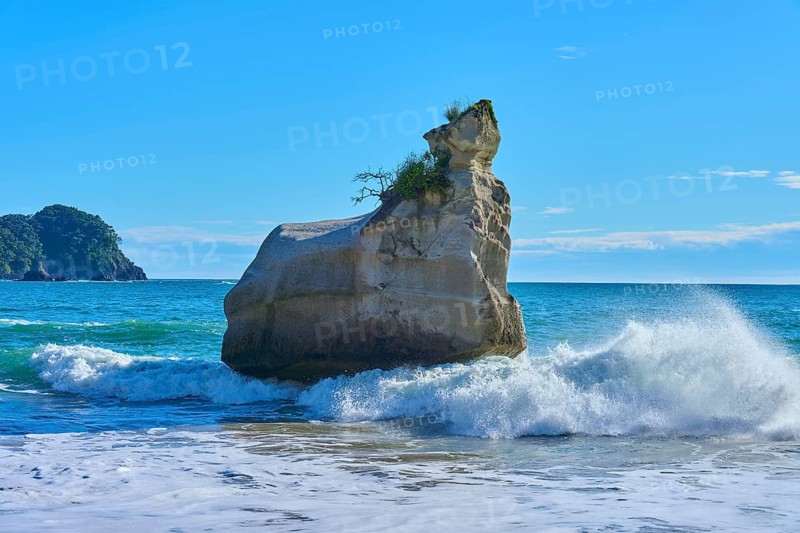 Energetic waves crash against a huge rock in the sea, Cathedral Cove, Hahei, Coromandel Peninsula, North Island, New Zealand, Oceania