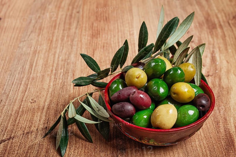 A mixture of olives, varieties of chalkidiki, Verdi giganti and Kalamata, in a bowl, top view, no people