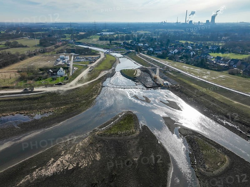 Dinslaken, Voerde, North Rhine-Westphalia, Germany - New Emscher estuary into the Rhine. Renaturalisation of the Emscher. Flood protection through land expansion. The decommissioned STEAG Voerde coal-fired power station in the background. The mouth of the Emscher into the Rhine was moved almost 500 metres north from Dinslaken to Voerde. Fish can now swim barrier-free up the new Emscher from the Rhine through a newly created floodplain area. Following the construction of a parallel sewer, the Emscher has been completely free of sewage since January 2022. The river was previously an open, above-ground combined sewer with rainwater and wastewater
