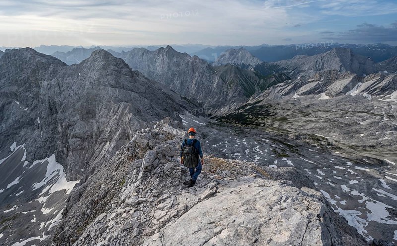 Mountaineer with helmet on a narrow rocky ridge, crossing the Jubiläumsgrat, Wetterstein range, Bavaria, Germany, Europe