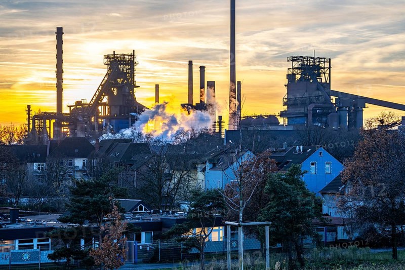 Blast furnace Schwelgern 1, Black Giant, Schwelgern 2 ThyssenKrupp Steel plant Schwelgern in Duisburg-Marxloh is part of the Bruckhausen steelworks, residential buildings in the Marxloh district, sunset, North Rhine-Westphalia, Germany, Europe