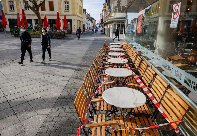 Krefeld, North Rhine-Westphalia, Germany - Krefeld city centre in times of the corona crisis during the second lockdown, a café restaurant has cordoned off the outdoor seating with flutter tape, most shops are closed, only a few passers-by are walking on Hochstraße, the main shopping street