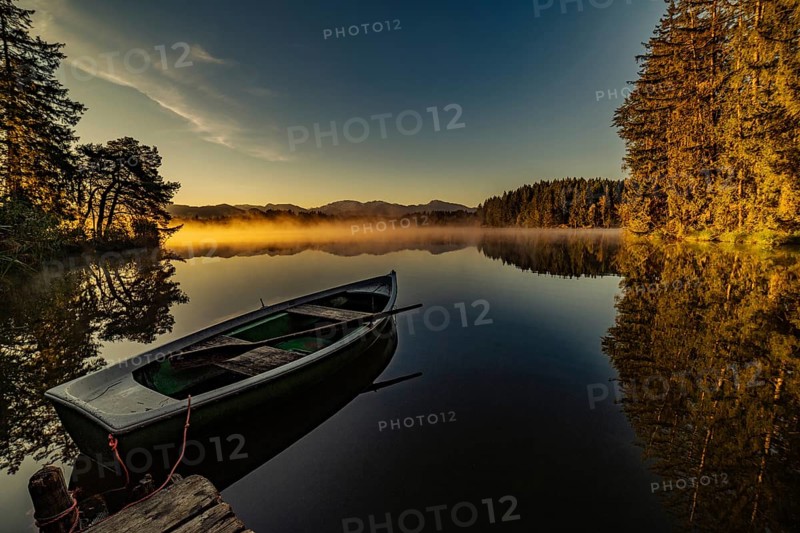 Boats in the autumnal Schmutter Weiher in the Allgäu near the municipalities of Halblech, Roßhaupten and Lechbruck in Ostallgäu in the foothills of the Alps