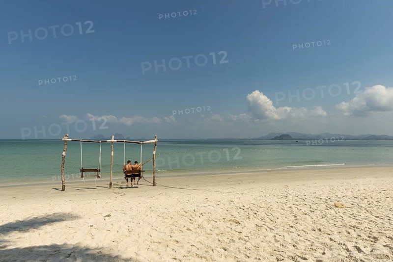 Gay couple in a swing on the beach of Koh Mook Island, Andaman Sea, Satun Province, Southern Thailand, Thailand, Asia