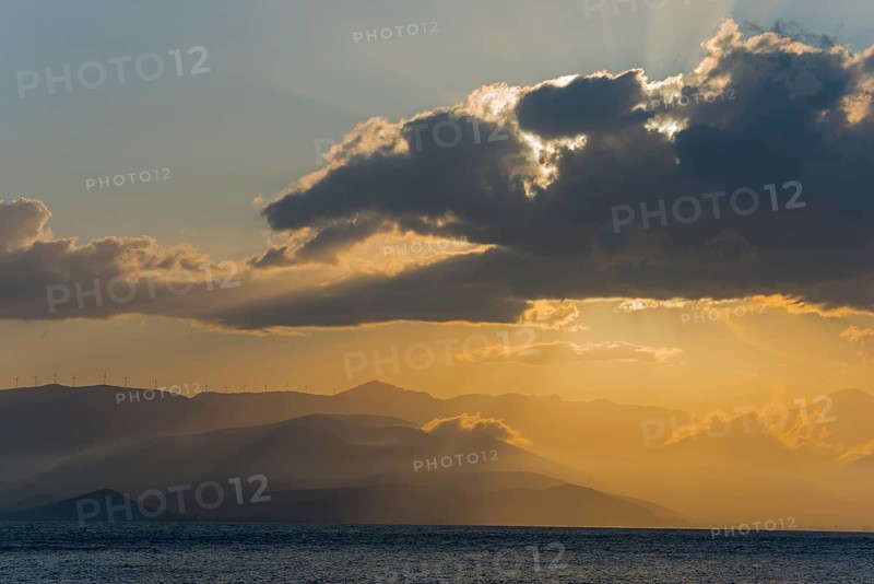 Dramatic sunset over the sea with clouds and mountains, radiant light and calm atmosphere, Agia Kyriaki, Nafplio, Nauplia, Nauplion, Nafplion, Argolis, Argolic Gulf, Peloponnese, Greece, Europe