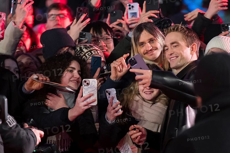 Robert Pattinson takes selfies with fans on the red carpet at the Special Gala of the film Mickey 17 at the 75th Berlinale at the Theater am Potsdamer Platz in Berlin on 15.02.2025