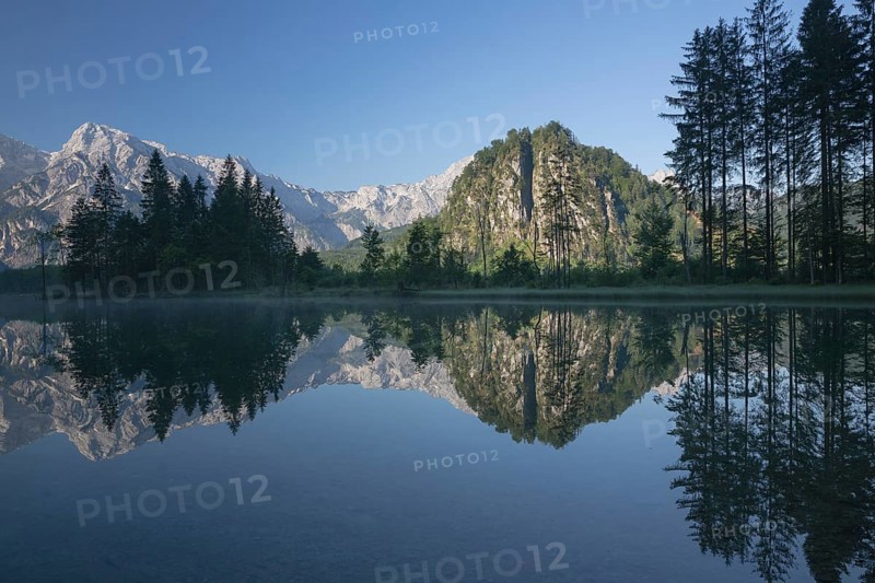 Lake Almsee in summer with totally smooth surface showing reflexion of the mountain Ameisstein