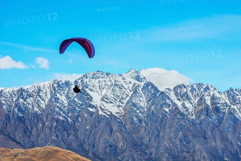 Paragliding over the snowcapped Remarkables mountain range, Queenstown, South Island, New Zealand, Oceania