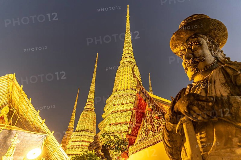 Giant Farang Guard and Chedi of the Buddhist temple Wat Pho at dusk, Bangkok, Thailand, Asia