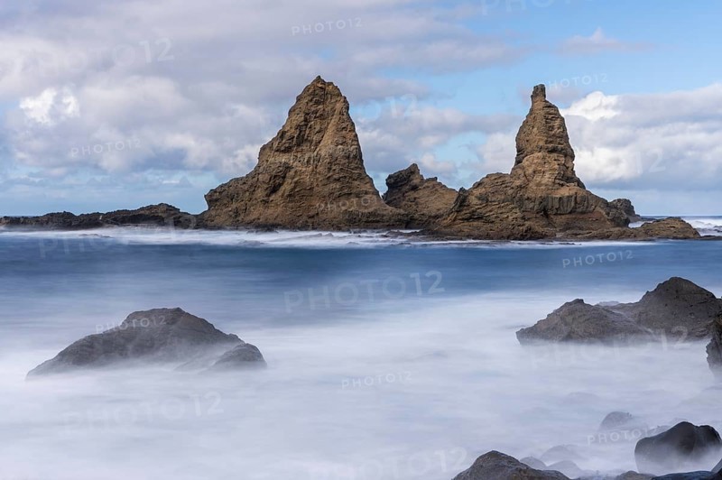 The north-west coast of La Gomera. The rock formation Baja de Los Roques, also known as Roques de Arguamul. Sea, waves, sun and clouds. Long exposure. Guillama, La Gomera, Canary Islands, Spain, Europe