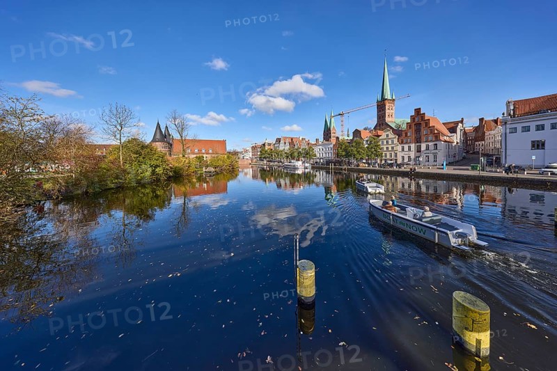 River Trave with quay wall, historic houses, Lübeck Holstentor, church towers of St. Marien and St. Petri, motorboat hire, reflection on the water surface, Hanseatic city of Lübeck, independent city, Schleswig-Holstein, Germany, Europe