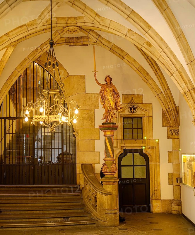 Gilded allegorical figure of Justitia with sword and scales and stairway to the town hall tower in the entrance hall of the New Town Hall on Marienplatz in the historic centre of Munich, Bavaria, Germany, for editorial use only, Europe