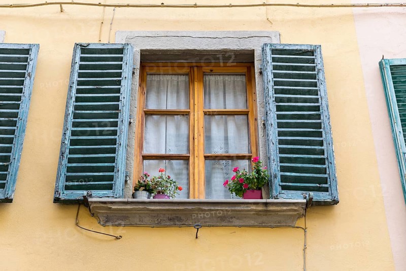 Wooden windows with flower pots and blue shutters in the medieval old town centre of Arezzo, Tuscany, Italy, Europe