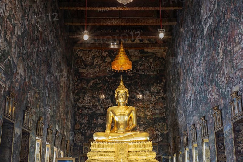 Golden Buddha statue, Phra Buddha Trilokachet, surrounded by exquisite murals, interior view of the Phra Ubosot or ordination hall, Wat Suthat Thepwararam, Royal Temple, Phra Nakhon, Bangkok, Thailand, Asia