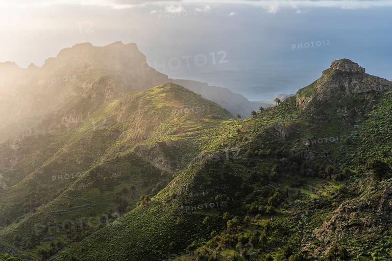 View of the Barranco Juan de Vera and its mountains, palm trees, rocks and sea. Near Mirador Degollada de Peraza. La Gomera, Canary Islands, Spain, Europe