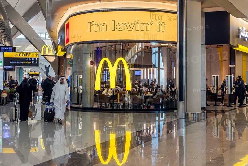 Abu Dhabi Airport, Zayed International Airport with passengers. McDonalds restaurant. The new Terminal A has a capacity of 45 million passengers per year. Modern architecture. Abu Dhabi, United Arab Emirates, UAE, Asia