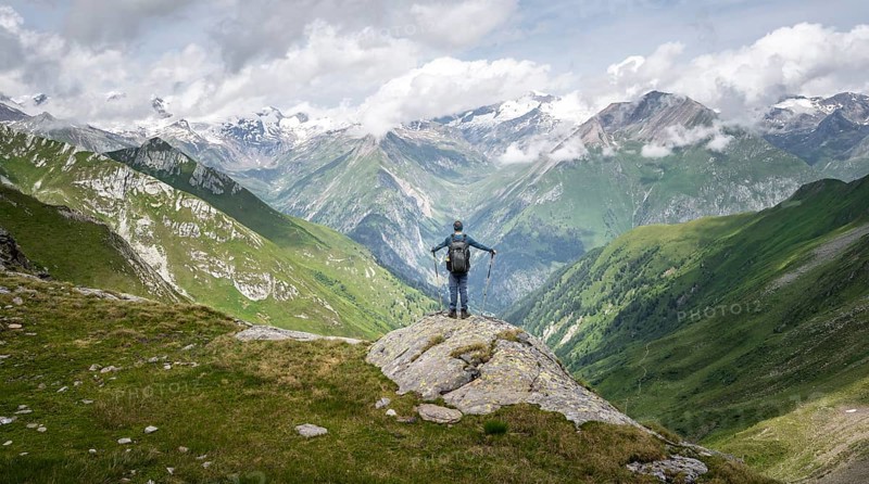 Mountaineer on a rock at the Mittagskögele, view of mountain peaks of the Venediger group and the Lasnitzental valley, Lasörling Höhenweg, Lasörling group, Hohe Tauern National Park, East Tyrol, Tyrol, Austria, Europe