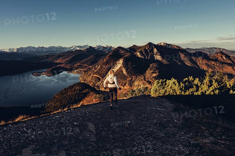 Trail running in autumn on the Jochberg on Lake Walchensee against the wonderful backdrop of the Alps, Bavaria, Germany, Europe