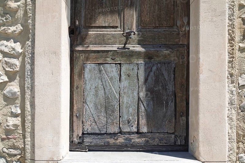 Weathered wooden door in an old, stone arched frame, Mediterranean atmosphere, Provence, France, Europe