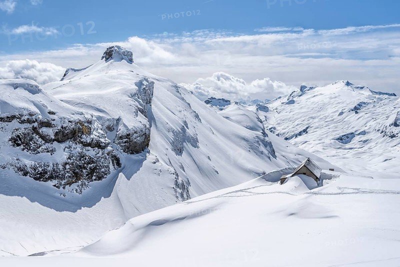 Snow-covered hut in winter, mountain landscape with snow, behind summit Rohrbachstein and Wildhorn, ascent to Wildstrubelhütte, Bernese Alps, Switzerland, Europe