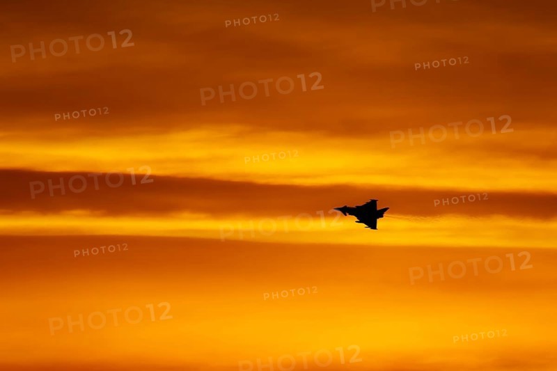 Eurofighter Typhoon silhouette of aircraft in RAF Royal air force colours flying at sunset, England, United Kingdom, Europe