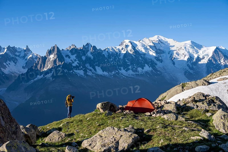 Photographer with telephoto lens next to red tent, mountain landscape in the morning light, mountain peak of Mont Blanc, Mont Blanc massif, Aiguilles Rouges, Chamonix-Mont-Blanc, Haute-Savoie, France, Europe