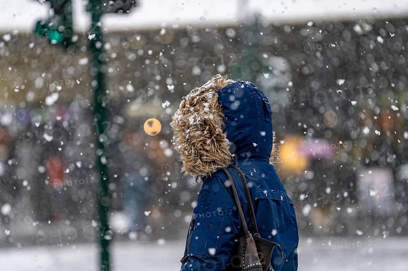 Winter weather, heavy snowfall, city centre traffic, passers-by in the snow, person with fur hood on winter jacket, North Rhine-Westphalia, Germany, Europe