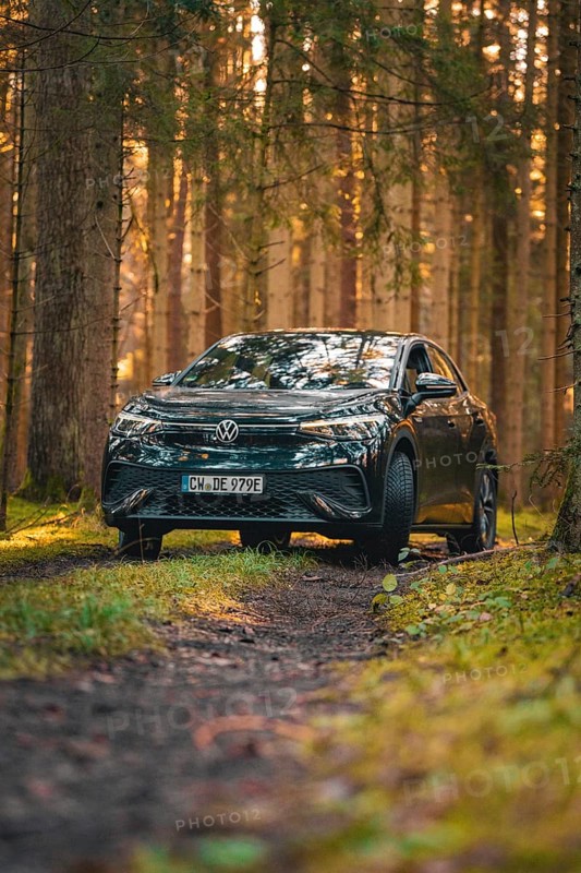 Car on a forest path at sunrise, surrounded by lively foliage, car sharing vehicle Deer Mobility, electric car VW ID5, Black Forest, Germany, Europe