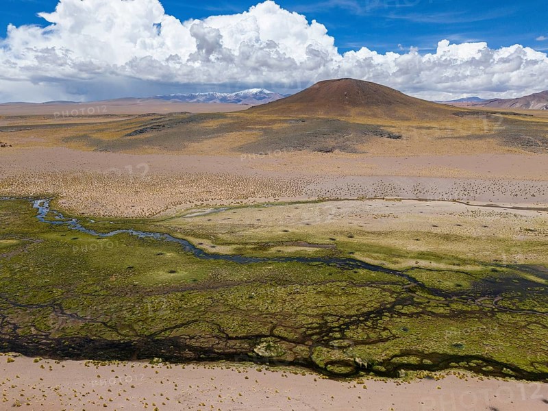 Rio Punilla, Los Nacimientos, Catamarca Province, Argentina, Aerial view of a desert landscape with a mountain under a cloudy sky, South America, Aerial view of a mountain and desert landscape with green patterns and cloudy sky, South America, Argentina, South America
