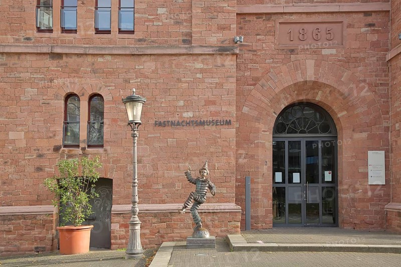 Entrance to the carnival museum, with sculpture of the Mainz Klepper-Garde, jester, dancing, merry, carnival, street lamp, inscription, red, bronze, old town, Mainz, Rhine-Hesse region, Rhineland-Palatinate, Germany, Europe