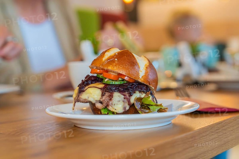 A juicy burger with vegetables served on a pretzel bun in the restaurant, autumn creations, Cafe Kuh, Deckenpfronn, Black Forest, Germany, Europe