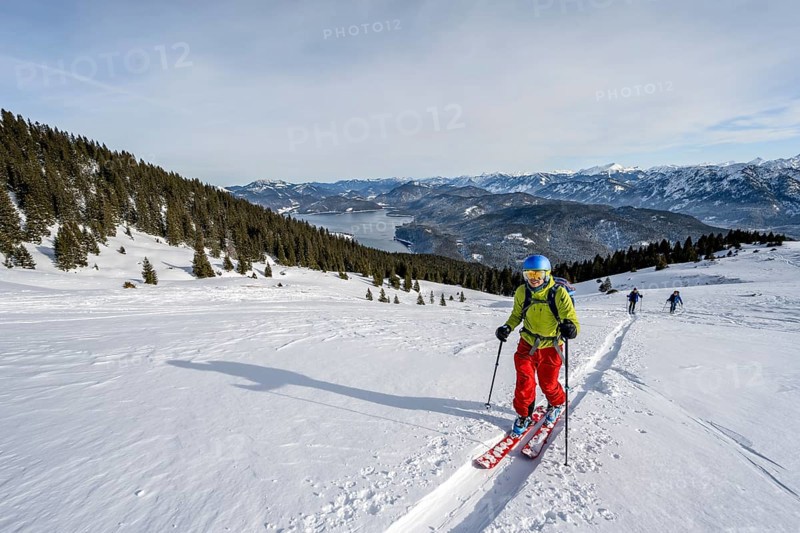 Ski tourers ascending Simetsberg, view of Walchensee and mountain panorama, Estergebirge, Bavarian Prealps, Bavaria Germany