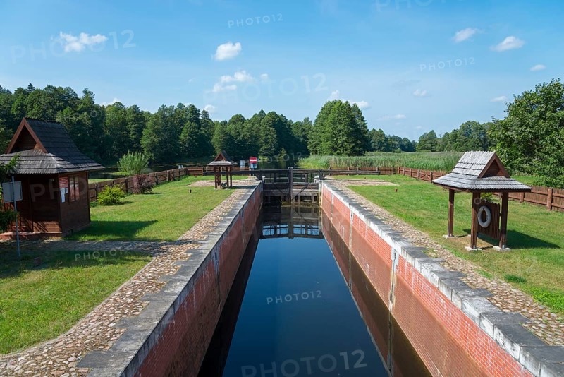 A narrow canal with a lock leads through a green forest landscape, Tartak Lock, Augustow Canal, Augustowski Canal, Suwalki, Podlaskie, Podlaskie, Poland, Europe