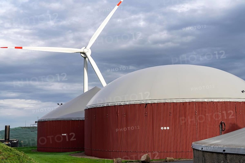 Biogas plant produces gas from various biomass, electricity is generated in combined heat and power plants with the biogas produced and sold to companies in the neighbouring industrial estate, the heat generated is fed into a local heating network, gas storage and wind power plant, Ense, North Rhine-Westphalia, Germany, Europe