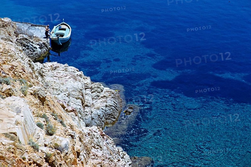Blick auf kleine offene Boote, die an der Küste des tiefblauen Meeres vertäut sind, Insel Ibiza, Balearische Inseln, Spanien, 1950er Jahre