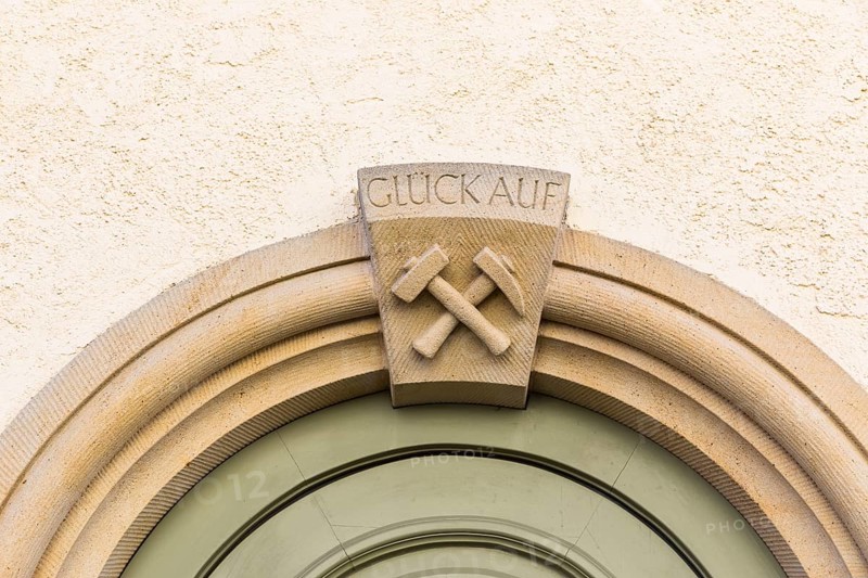 Mallet and iron and inscription Glück Auf, on the portal of a residential building at Pfarrgasse 16 in Freiberg, Saxony, Germany, Europe