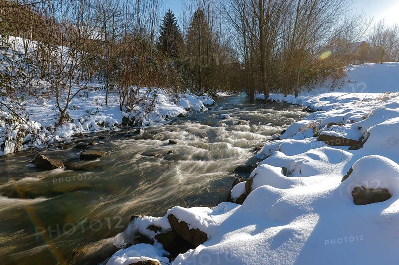 Dortmund, North Rhine-Westphalia, Germany - Sunny winter landscape in the Ruhr area, ice and snow on the renaturalised Emscher, the ecological conversion of the Emscher system consists of the construction of a central wastewater treatment system in the Ruhr area, the construction of underground sewers and the renaturalisation of the Emscher and its tributaries