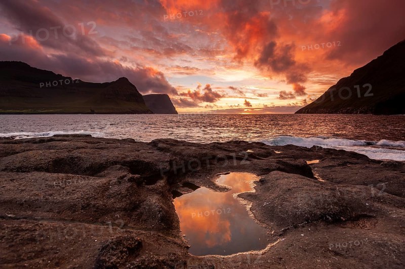 Sunset over the sea between steep mountain slopes, reflection in calm pool on rocks, Vidareidi, Vidoy Island, Viðareiði, Viðoy Island, Faroe Islands, Denmark, Europe